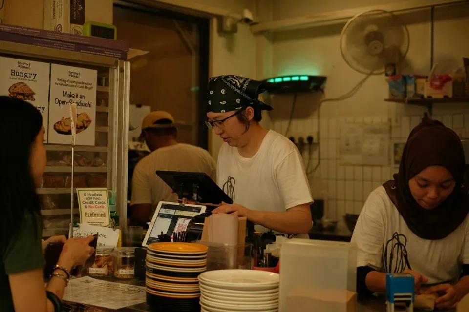 Staff serving customers at the counter of a small café